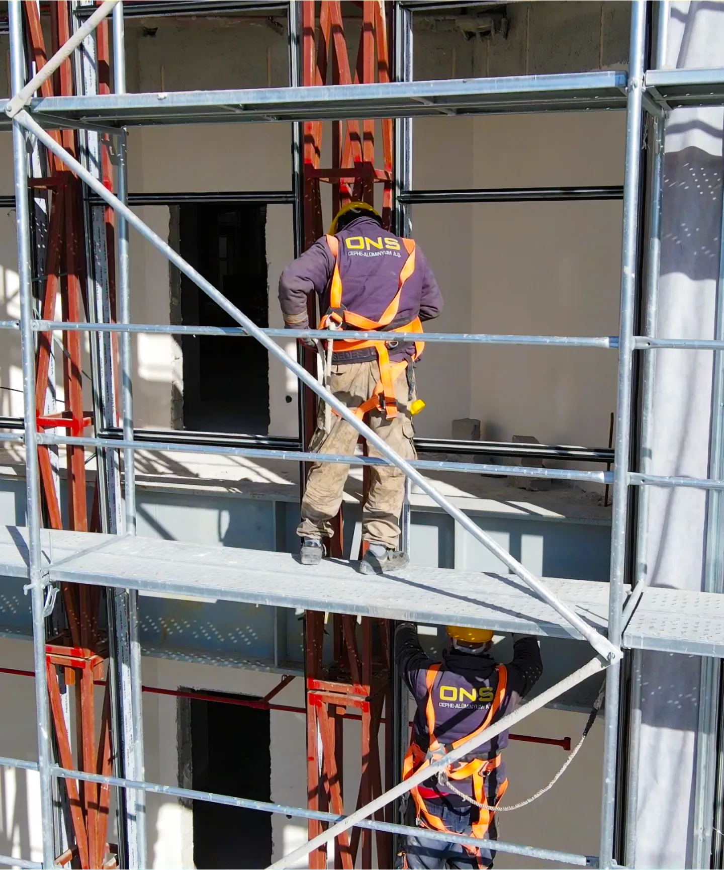 ONS CEPHE ekibi iskelede ahşap desenli fibercement ve cam cephe montajı yapıyor